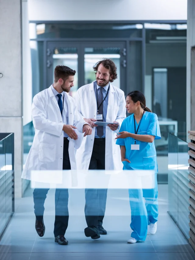 doctor-holding-digital-tablet-having-discussion-with-colleagues